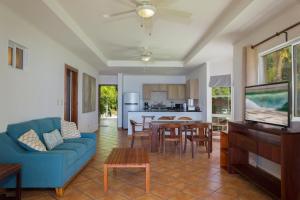 uma sala de estar com um sofá azul e uma mesa em Villas Iguana A-14 Beachfront Condo em Iguana