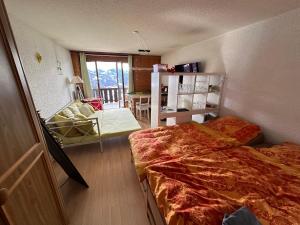 En eller flere senge i et værelse på "Le Ptit Nid" studio avec vue à couper le souffle à Leysin !