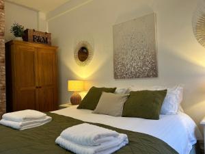 a bedroom with a bed with two towels on it at Whitchurch High Street Hideaway in Whitchurch