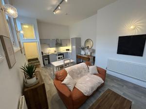 uma sala de estar com um sofá e uma cozinha em Whitchurch High Street Hideaway em Whitchurch