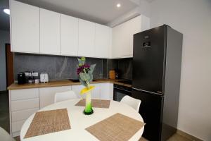 a kitchen with a table with a black refrigerator at NOVA Sea View Apartments in Durrës