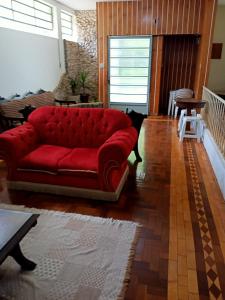 a red couch sitting in a living room at Casarão ao lado do Hotel Majestic in Águas de Lindóia