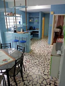 uma cozinha com paredes azuis, mesas e cadeiras em Casarão ao lado do Hotel Majestic em Águas de Lindóia