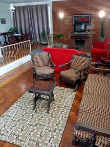 sala de estar con sofá rojo y sillas en Casarão ao lado do Hotel Majestic en Águas de Lindóia