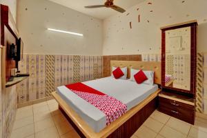 a bedroom with a bed with red pillows and a mirror at Hotel O Vaishali Garden in Rānchī