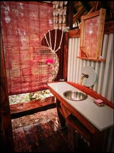 La salle de bains est pourvue d'un lavabo et d'une fenêtre. dans l'établissement L'Auberge Polynésienne, à Tevaitoa