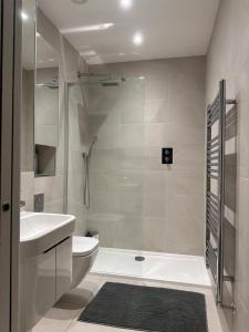 a bathroom with a shower and a toilet and a sink at Black Frairs Apartments in London