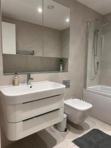 a bathroom with a sink and a toilet and a mirror at Black Frairs Apartments in London