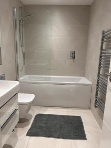 a bathroom with a tub and a toilet and a sink at Black Frairs Apartments in London