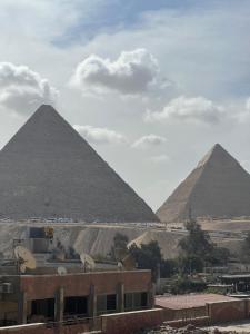 een uitzicht op de piramides van Giza vanuit een gebouw bij The Home Boutique Hotel Pyramids Inn in Caïro