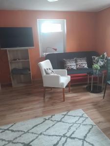 sala de estar con sofá y silla en Ferienwohnung Gisela, en Jockgrim