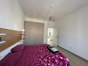 a bedroom with a large bed with a purple blanket at Appartamento nel Borgo in Turin