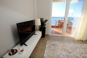 a living room with a flat screen tv on a white cabinet at NOVA Sea View Apartments in Durrës