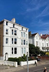 un edificio bianco sul lato di una strada di Stylish elegant two bedroom apartment overlooking Southsea Common and the Solent a Portsmouth