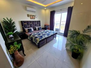a living room with a bed and a large window at 1 Bed Modern Apartment, Pool, Gym, Cinema in Lahore