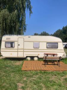 a rv parked in a field with a picnic table at Camping Rogowo in Mrzeżyno