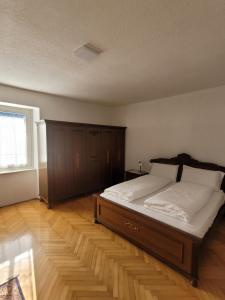 een slaapkamer met een groot bed en een houten vloer bij Casa Pontesana in Pellizzano