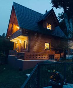 una piccola casa in legno con luci accese di Planinska kuća Mali Raj a Mrkonjić Grad