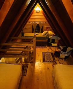 a attic room with three beds and a table at Planinska kuća Mali Raj in Mrkonjić Grad