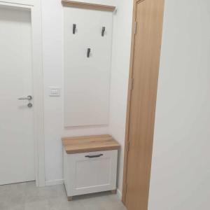Łazienka z białymi drzwiami i drewnianą szufladą w obiekcie M Lux Apartment Zlatibor w mieście Zlatibor