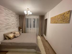 1 dormitorio con cama y lámpara de araña en Superbe villa à 2 km centre ville de Colmar en Horbourg