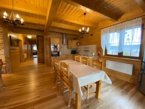 uma cozinha com mesa e cadeiras num quarto em Nowica 71 Dom Jodłowy em Nowica