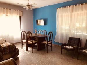 une salle à manger avec une table, des chaises et un mur bleu dans l'établissement Pecan, à Concepción del Uruguay