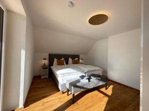 een slaapkamer met een bed en een tafel. bij Das Lungau View - NEUERÖFFNUNG in Mauterndorf