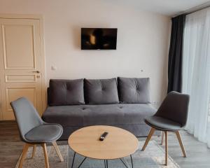 uma sala de estar com um sofá e duas cadeiras e uma mesa em Svečių namai Žara em Tytuvėnai
