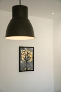 a black lamp with a picture of a tree on a wall at Lucas apartment in Čapljina