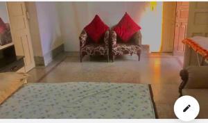 ein Wohnzimmer mit 2 Sofas und roten Kissen in der Unterkunft Cheerful in Kānpur