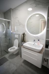a bathroom with a sink and a toilet and a mirror at Lucas apartment in Čapljina