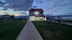 a house on a grassy field with a building at Lucas apartment in Čapljina