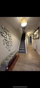 a hallway with a staircase with a bench and a stair case at Home in Kilmuckridge in Wexford