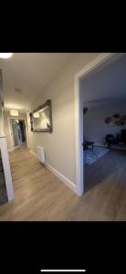 an empty living room with a hallway with a hard wood floor at Home in Kilmuckridge in Wexford