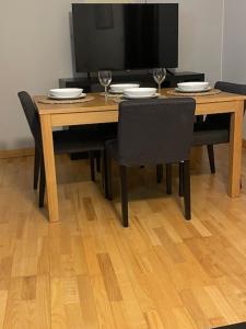 a dining room table with chairs and a television at Apartmán Pistácia 2 priame centrum BB in Banská Bystrica