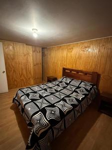 1 dormitorio con 1 cama con edredón blanco y negro en Casa en Valdivia, en Valdivia