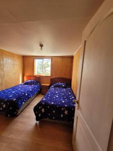 1 dormitorio con 2 camas y ventana en Casa en Valdivia, en Valdivia