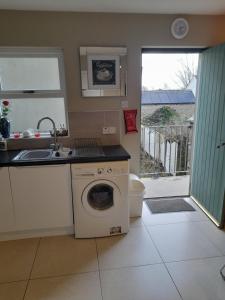 a kitchen with a washing machine and a sink at 4 Bleach Green Apartments in Ballycastle