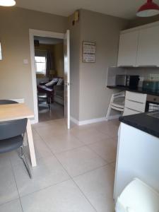 a kitchen and living room with a table and chairs at 4 Bleach Green Apartments in Ballycastle