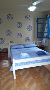 1 dormitorio con 1 cama con colcha azul y blanca en Suítes no Centro, en Búzios