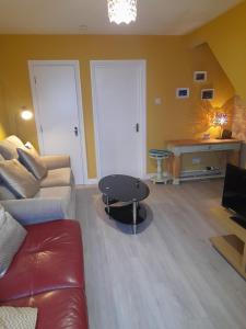 a living room with a couch and a table at 4 Bleach Green Apartments in Ballycastle