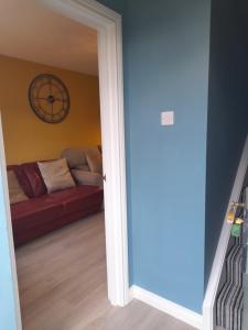 a living room with a red couch and a clock at 4 Bleach Green Apartments in Ballycastle