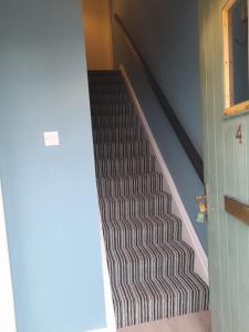 a stairway with a black and white staircase at 4 Bleach Green Apartments in Ballycastle