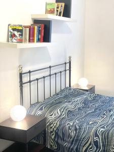 - une chambre avec un lit et une étagère avec des livres dans l'établissement Anselmo Max, à Turin