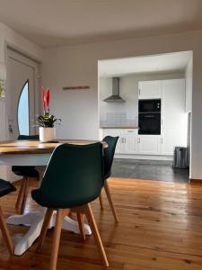 a kitchen with a table and chairs in a room at Gîte L’Erable in Haverskerque