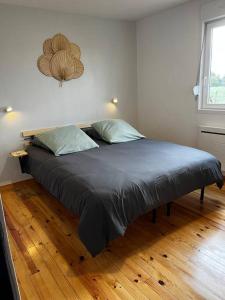 a large bed in a bedroom with a wooden floor at Gîte L’Erable in Haverskerque