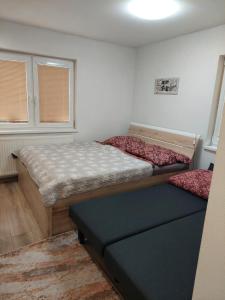 a bedroom with two beds and a bench in it at BIKE apartments 2 in Hodruša