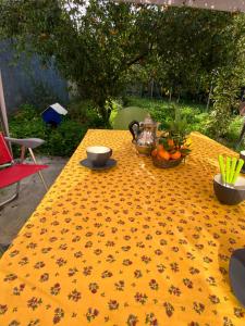 a table with a yellow table cloth with flowers on it at Casa Deloy in Elmas