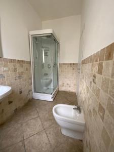 a bathroom with a glass shower and a toilet at Casa Deloy in Elmas